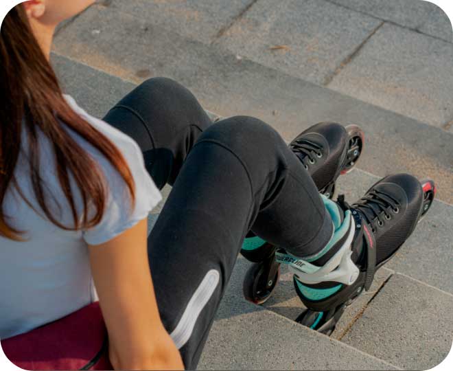 Overhead view of a woman sitting on a step wearing Powerslide inline skates