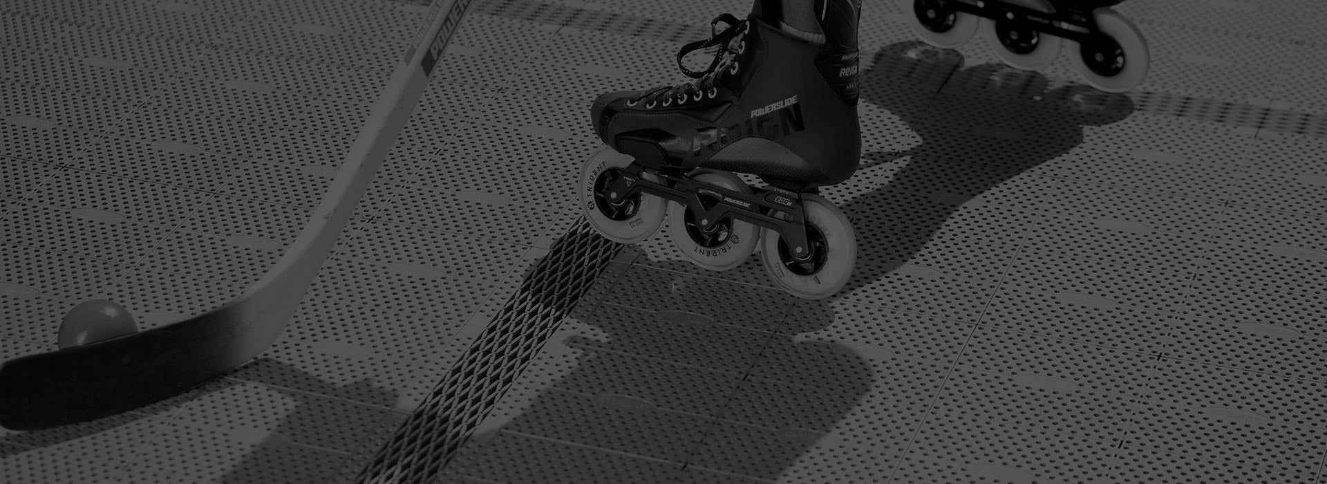 A black and white image of a hockey stick and 3-wheel Powerslide Reign inline roller hockey skates