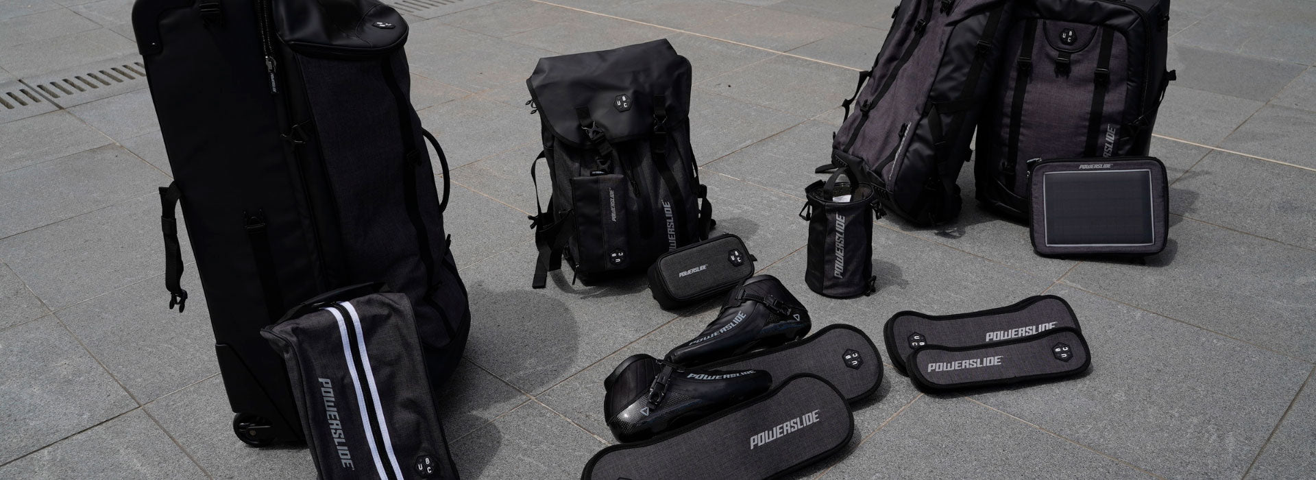 A range of different sized bags, backpacks and accessories site on the ground