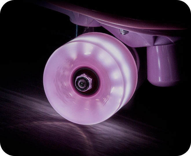 A close-up image of pink neon wheels on a roller skate