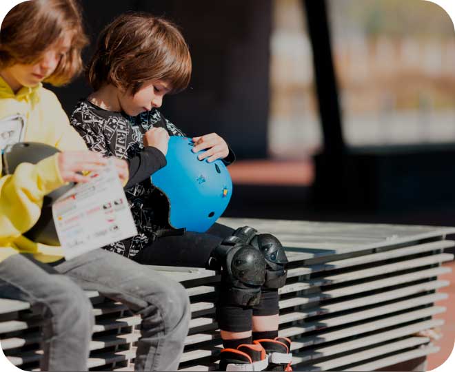 Two children sitting and examining their Powerslide helmets