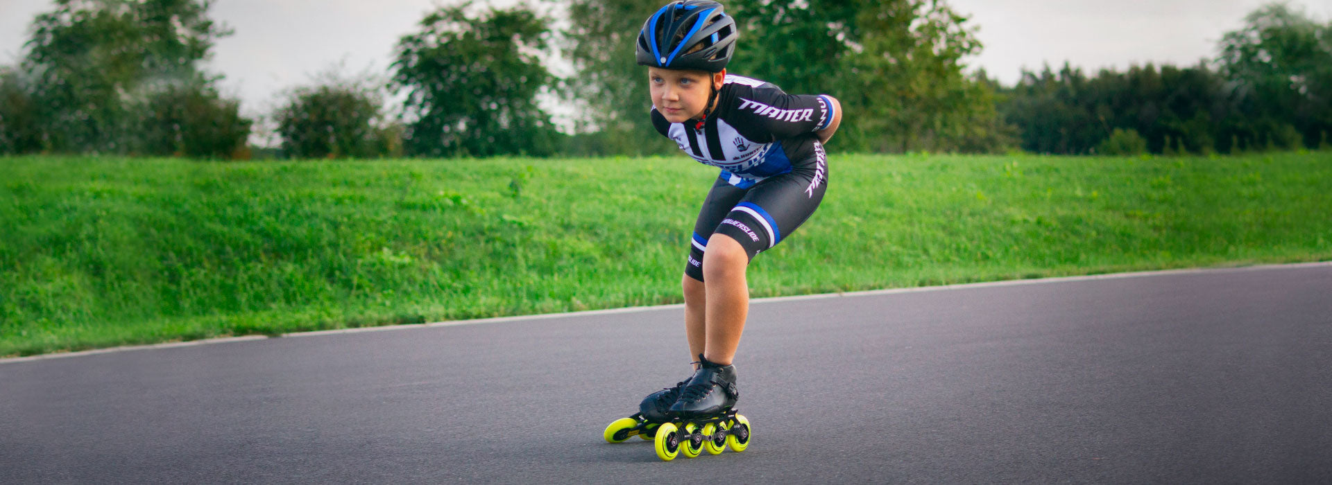 A young boy on smooth pavement mid-stride while using Powerslide inline race skates