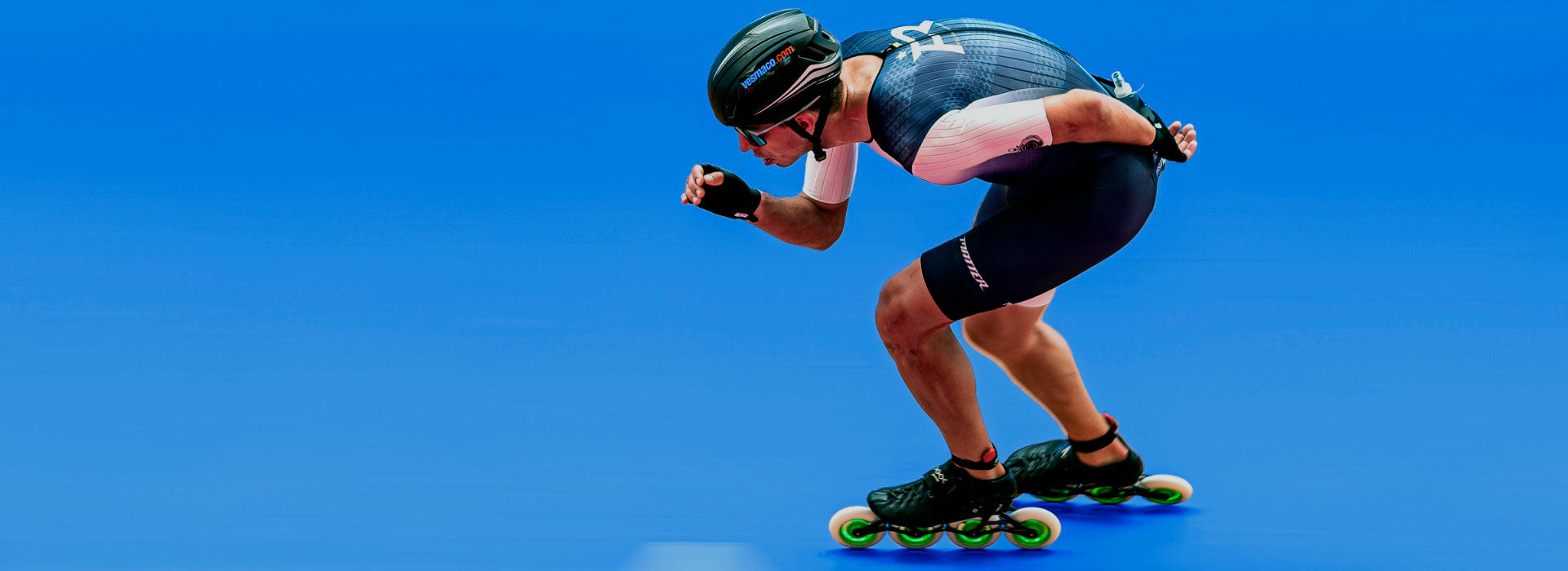 An inline speed skater wearing a tight blue outfit skating toward the camera 